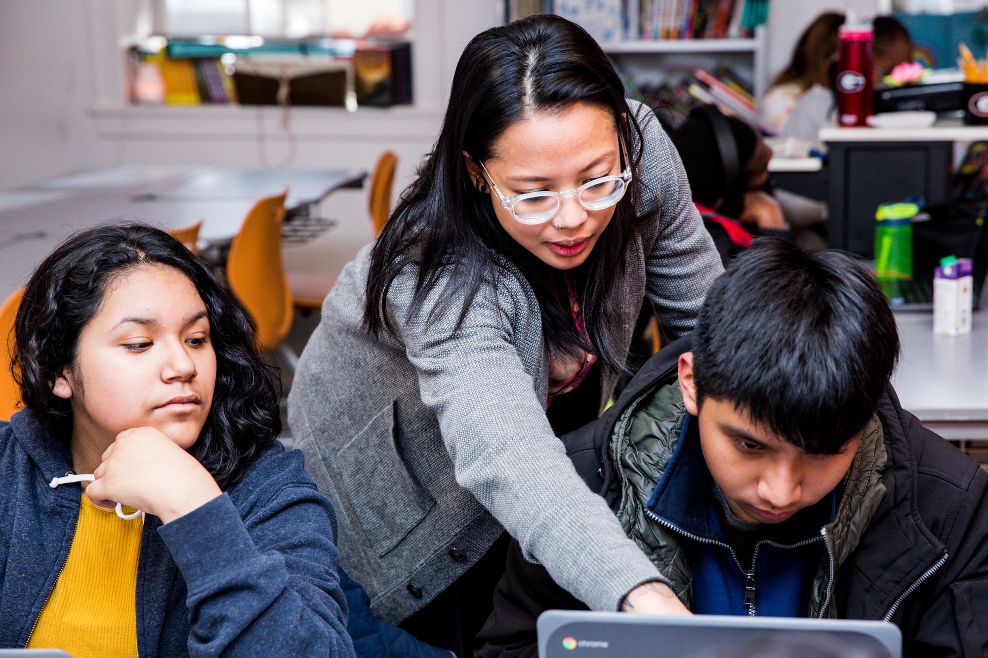 Students collaborating with teacher.