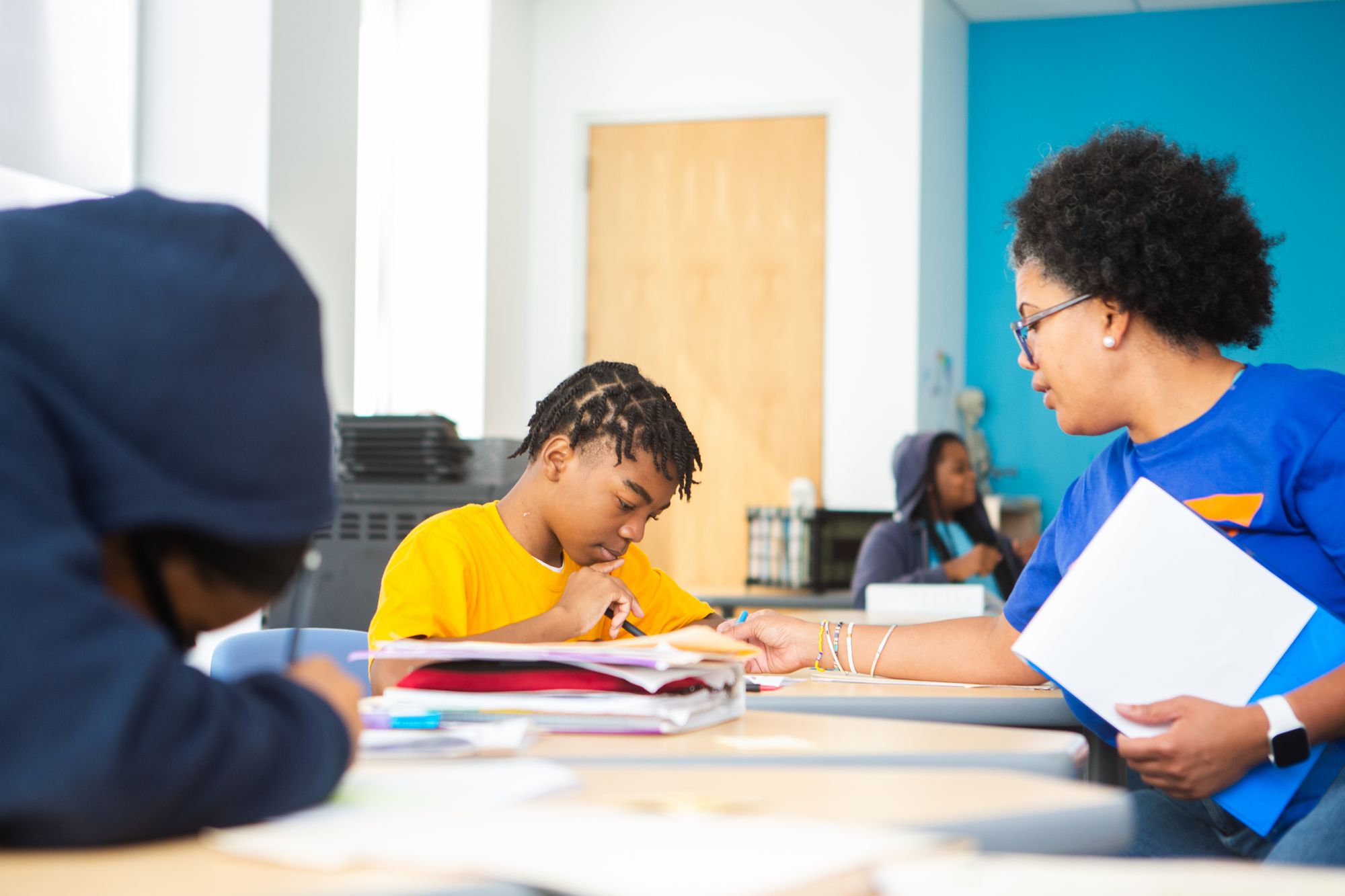 A teacher helps a student with a CommonLit lesson.
