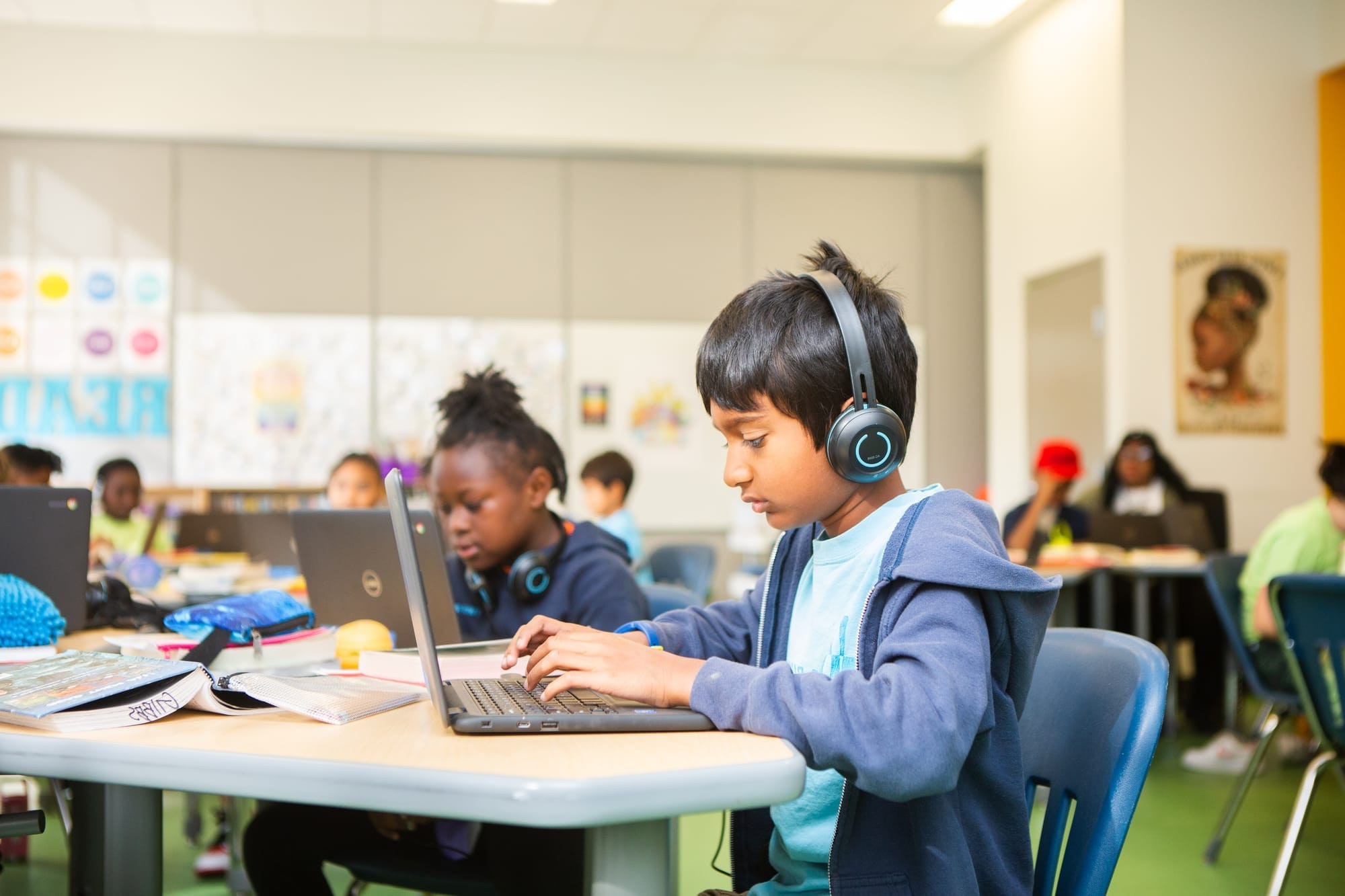 Student with headset on working at a laptop computer