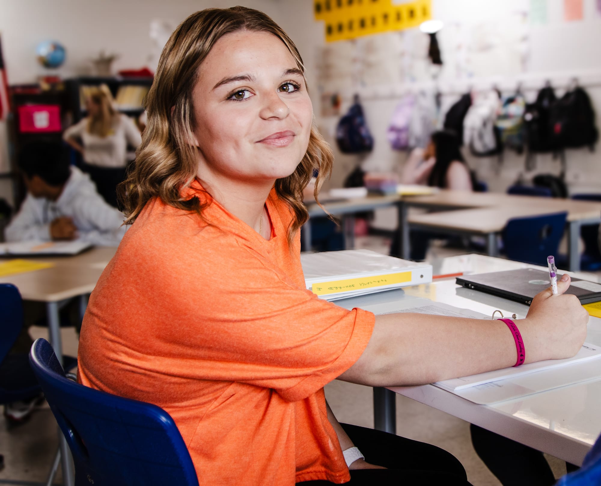 A student writing at her desk.