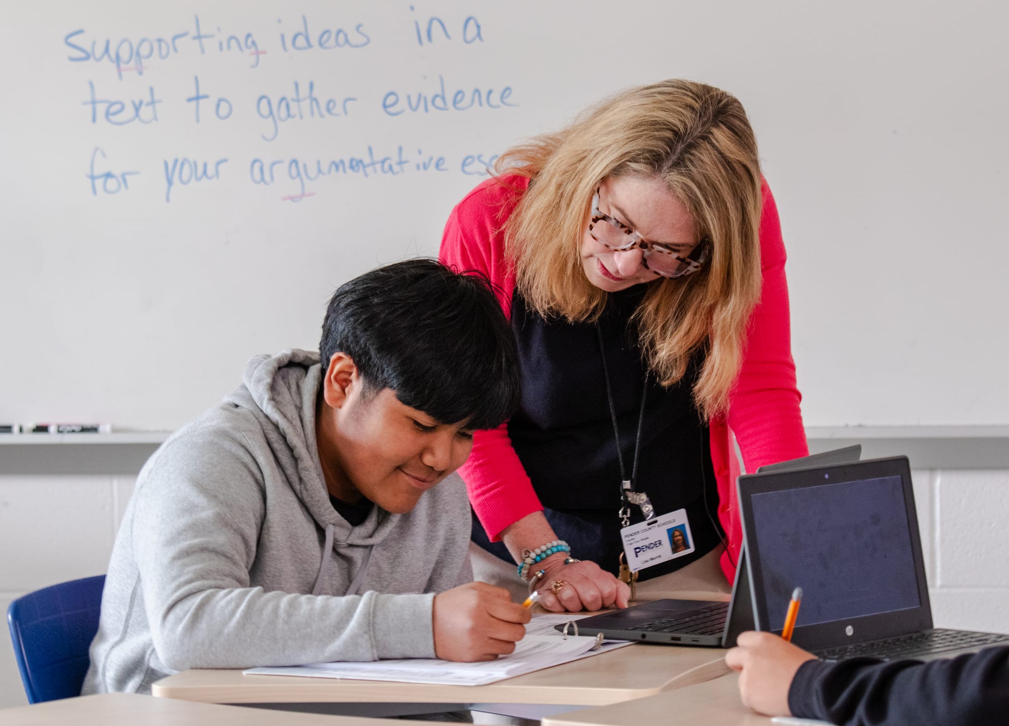 A teacher assisting a student with their CommonLit 360 assignment.