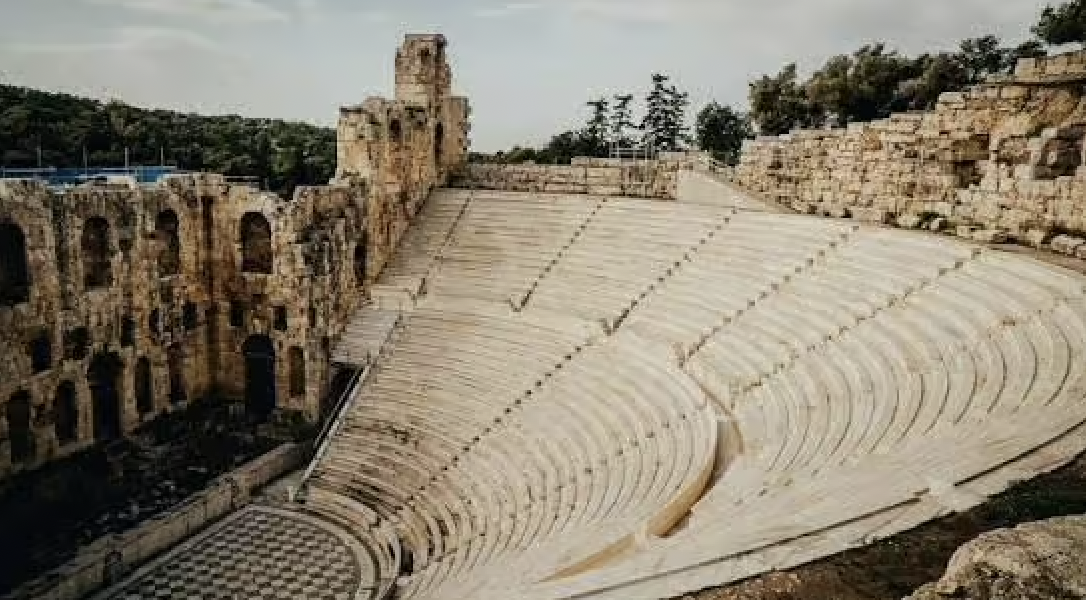 Ancient stone amphitheater with curved tiered seating.