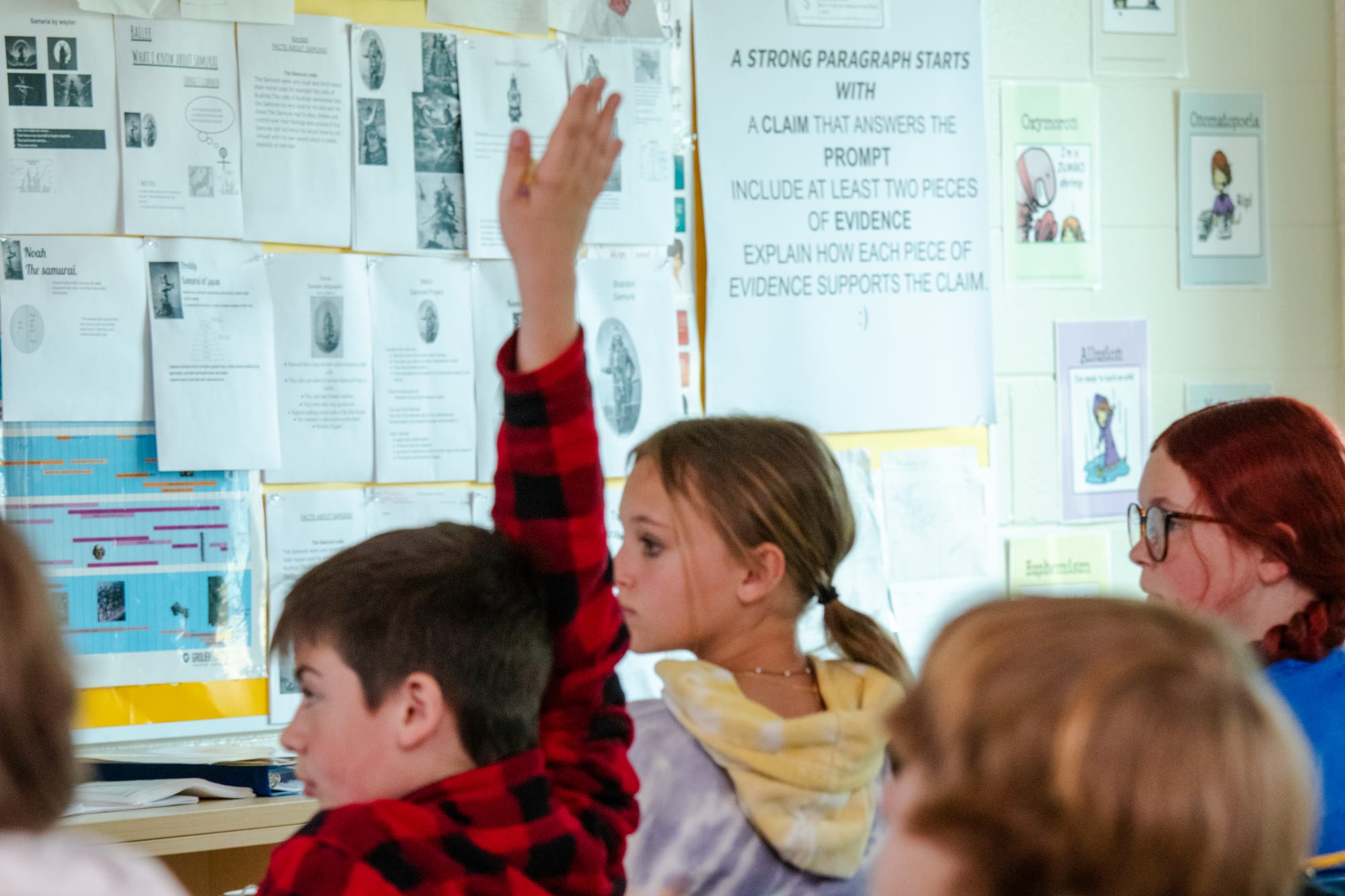 Student raising his hand in a CommonLit 360 classroom.