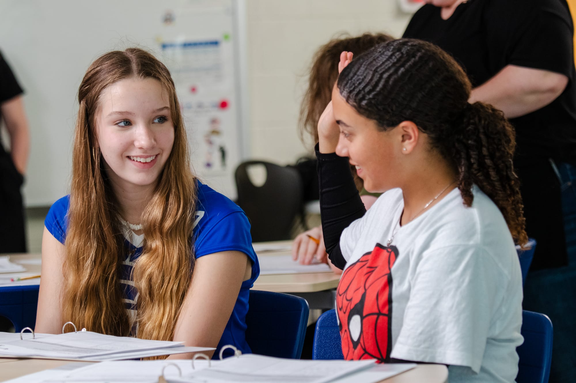 Two middle school students smiling and collaborating in a CommonLit classroom.