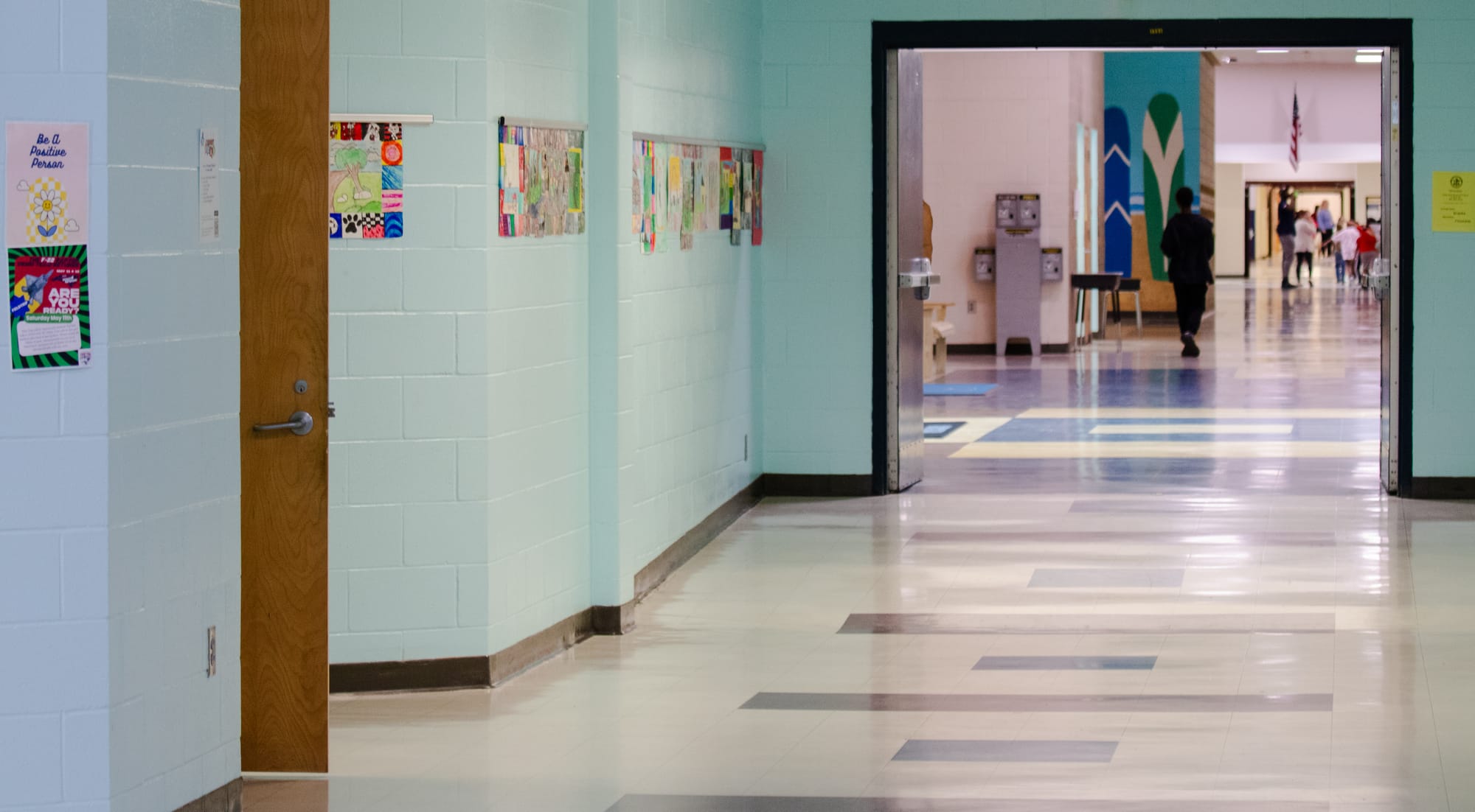 An empty school hallway with blue walls