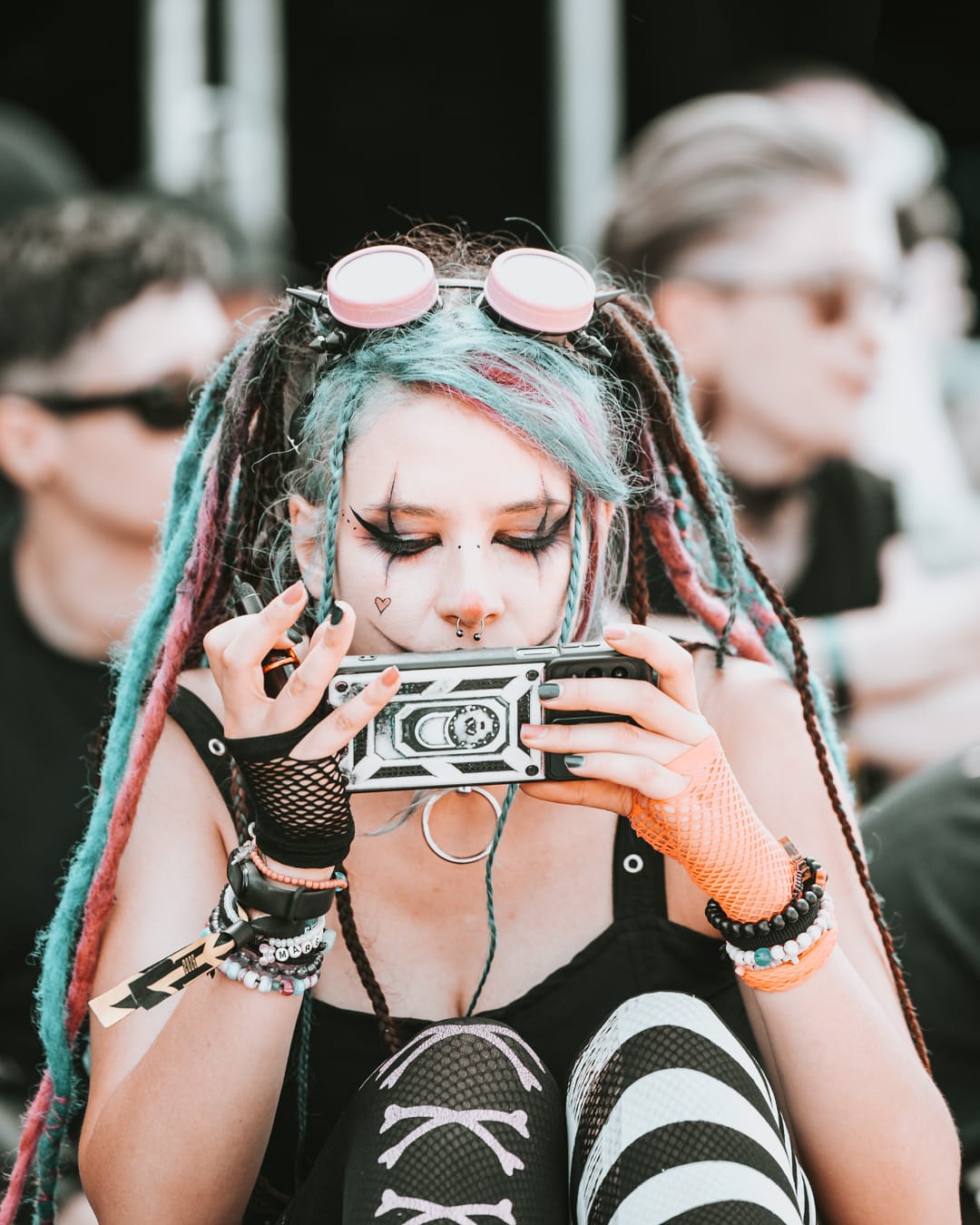 Festivalbesucherin mit bunten Dreadlocks und kleiner Kamera beim M’era Luna Festival 2026 in Hildesheim.