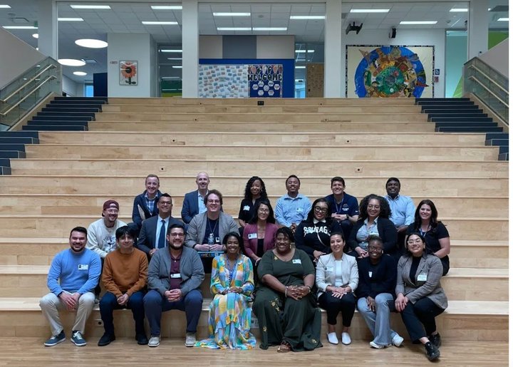 A group of people sit on a school staircase.