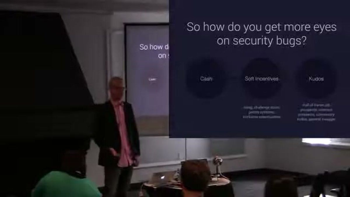 Casey Ellis on stage at SOURCE Boston 2014, next to a slide asking "So how do you get more eyes on security bugs?"
