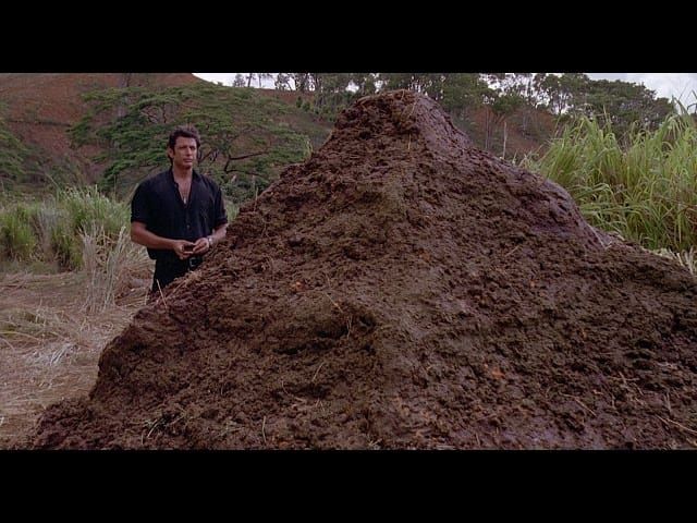 Jurassic Park still of Ian Malcolm standing next to one big pile of dinosaur dung