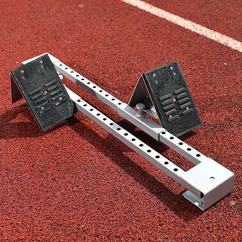 a racing starting block on a track, ready for feet to push against