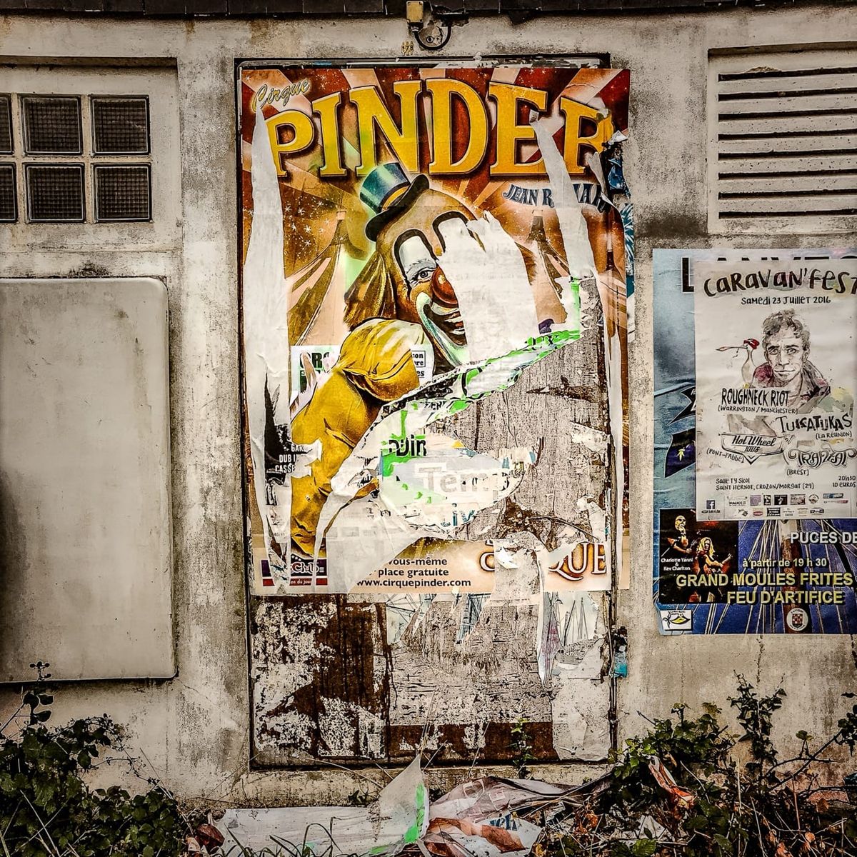 Vieille affiche publicitaire délabrée du Cirque Pinder sur un mur en Finistère