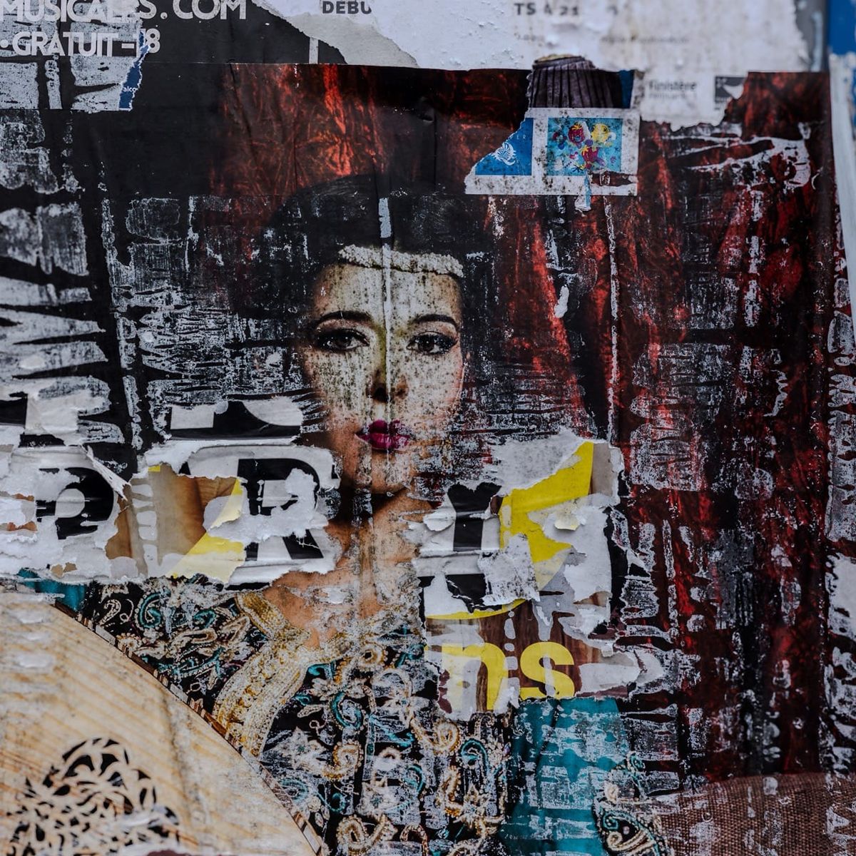 Affiche déchirée d'une chanteuse orientale avec son oud, sur un mur près du parking de la Résistance à Quimper