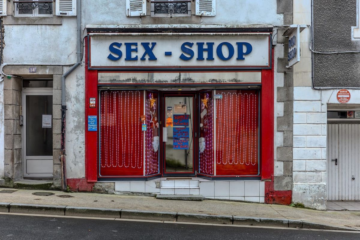 Sex-shop historique rue Jules Ferry à Quimper, devanture rouge avec enseigne bleue et guirlandes lumineuses
