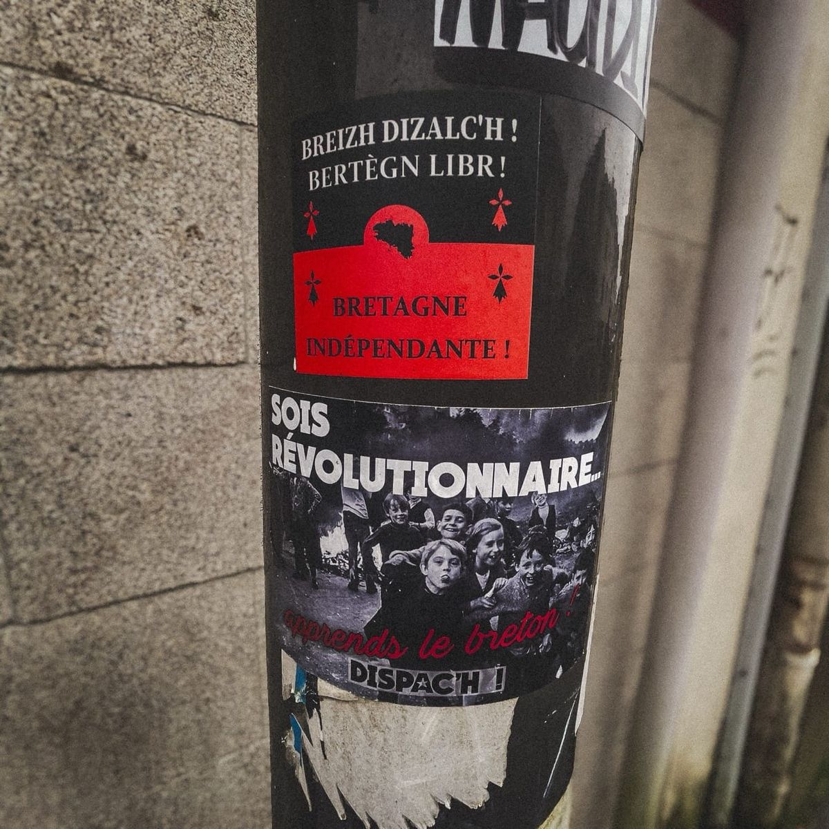 Stickers Breizh Dizalc’h et militant breton collés sur un poteau dans une rue de Quimper