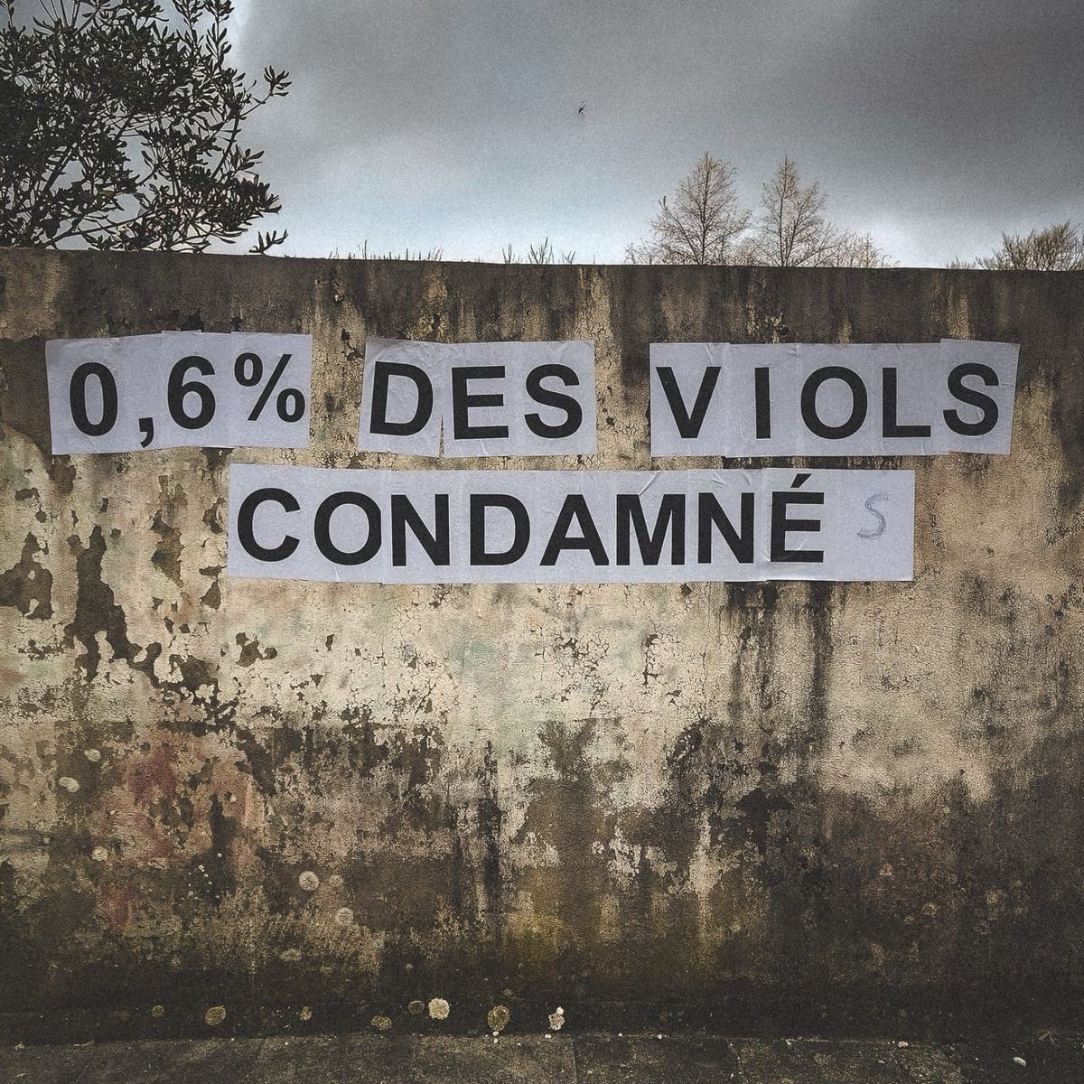 Affiche collée sur un mur en Bretagne avec correction manuscrite au stylo ajoutant un S