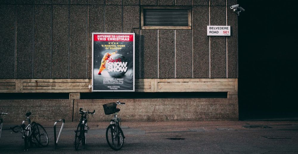 건물 벽면에 포스터 형태의 광고판이 붙어 있고, 이를 CCTV가 촬영하는 예시.