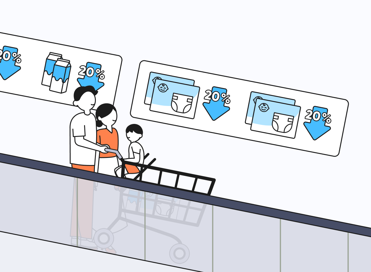 대형마트 내 에스컬레이터에 젊은 부모가 카트에 아이를 태운 채 탑승 중이다. 가족의 뒤로는 광고 사이니지가 있고, 우유와 기저귀 광고가 송출되고 있다.