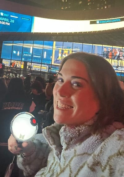 woman holding BTS lightstick outside of Barclays Center