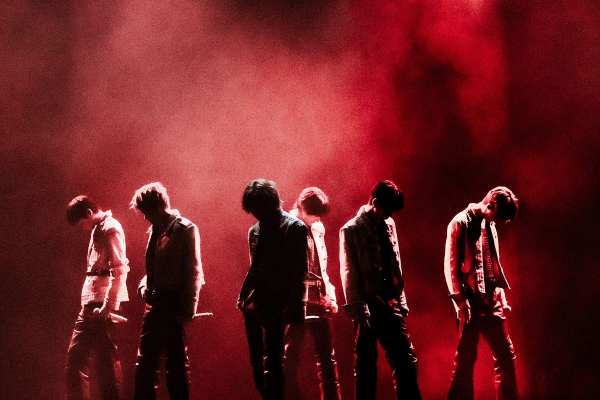 RIIZE on stage, shadowed in red and black