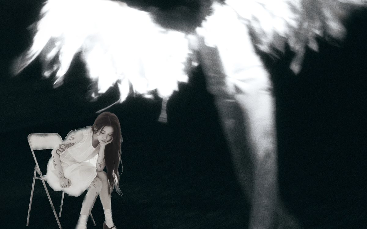 A black background. In the bottom right corner, a woman in a white dress, looking down at the floor, seated on a folding chair, overshadowed by an out-of-focused winged person 