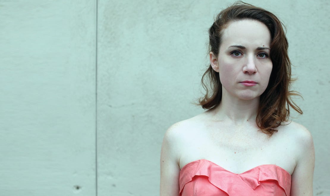A woman standing in front of a wall.