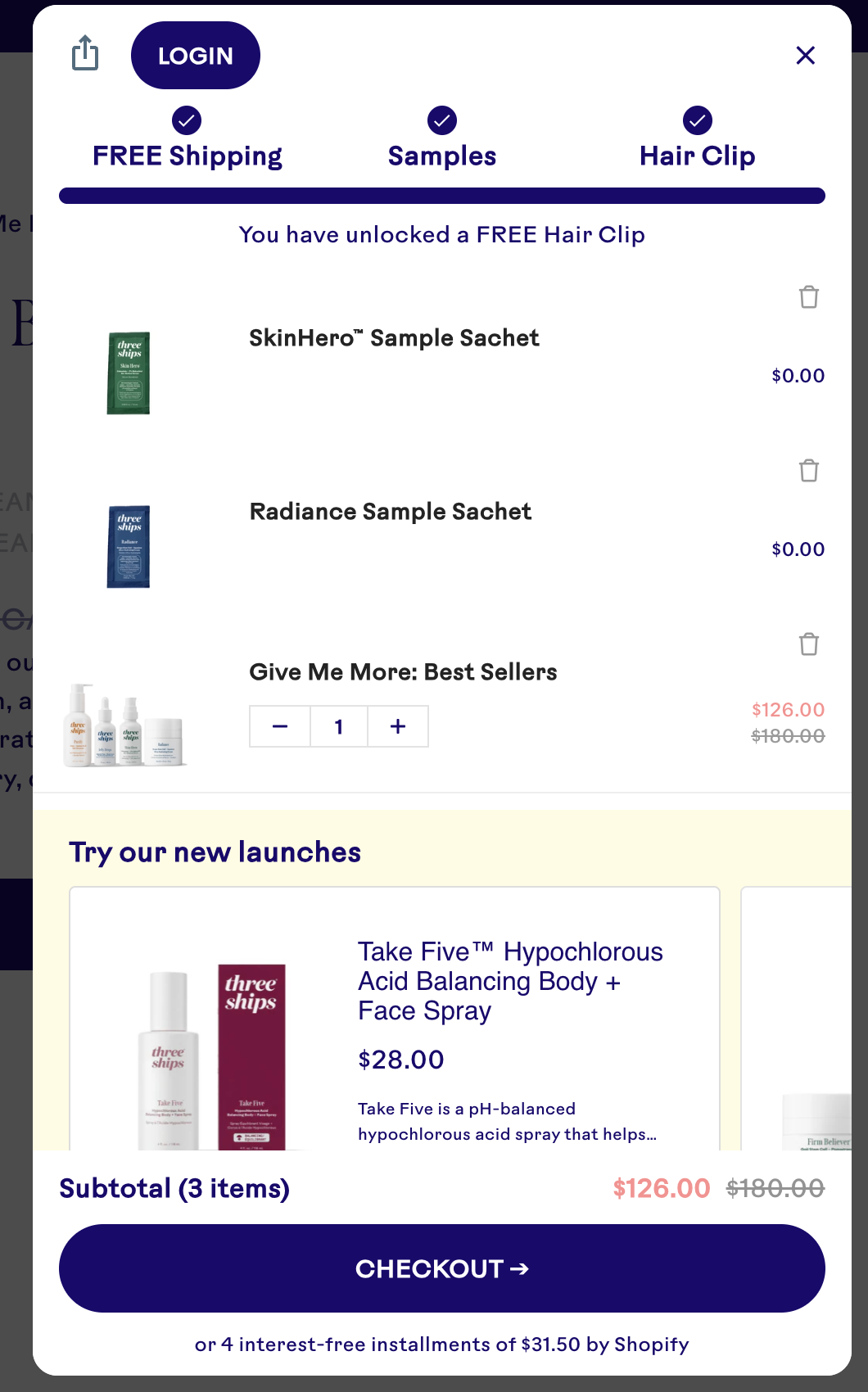 Shopping cart showing a Three Ships skincare bundle with free samples, a free hair clip, and checkout subtotal.