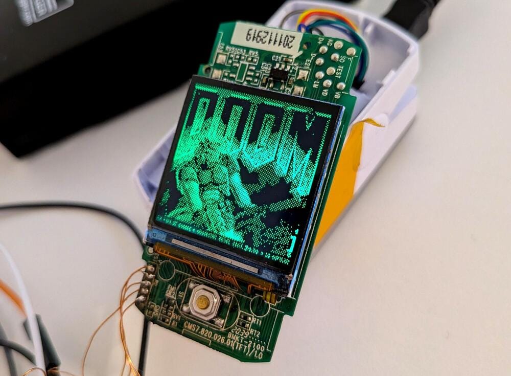 a naked pulse oximeter with an LED display, showing its computer chip, with the "Doom" splash screen on the display.