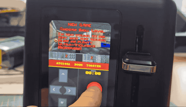 an animated GIF of a smart toaster with an LED display, it saying, "Push toast!", the person flipping the handle of the toaster down, and using the touch-screen display to navigate the first-person shooter, Doom.