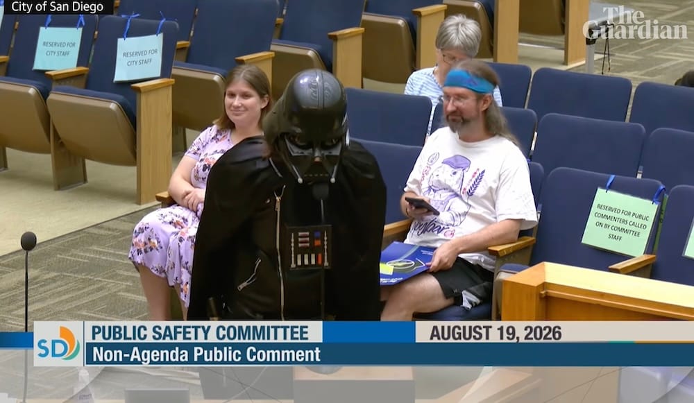 a screenshot from a San Diego city council live stream featuring a speaker talking about Flock dressed as Darth Vader.