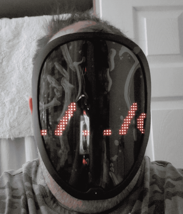 @da_667 wearing an electronic mask with a scrolling LED display, which reads: "../.../.../etc/passwd" signifying a path traversal bug.