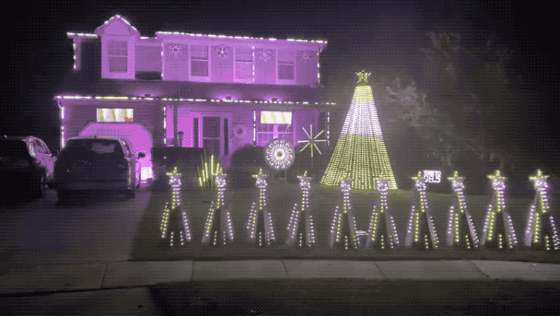 An animated GIF of Joyce's house and front lawn lit up with Christmas and holiday lights and decorations.