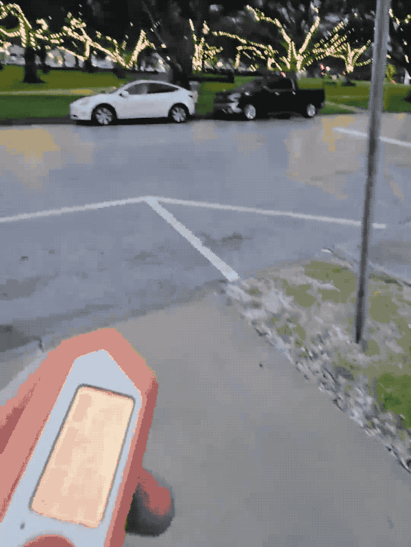 A short animated GIF of someone using a Flipper Zero to remotely (but nearby) open the charging port on a nearby Tesla.