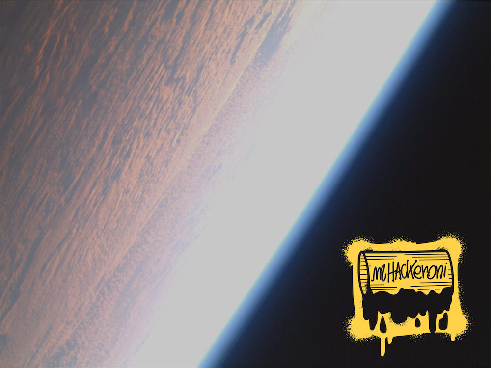 A photo from space looking at earth in orbit. The photo was taken from a satellite and contains the mhackeroni team logo.