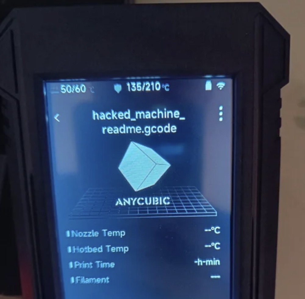 A photo of the display on an Anycubic 3D printer, which displays a filename that says "hacked_machine_readme.gcode".