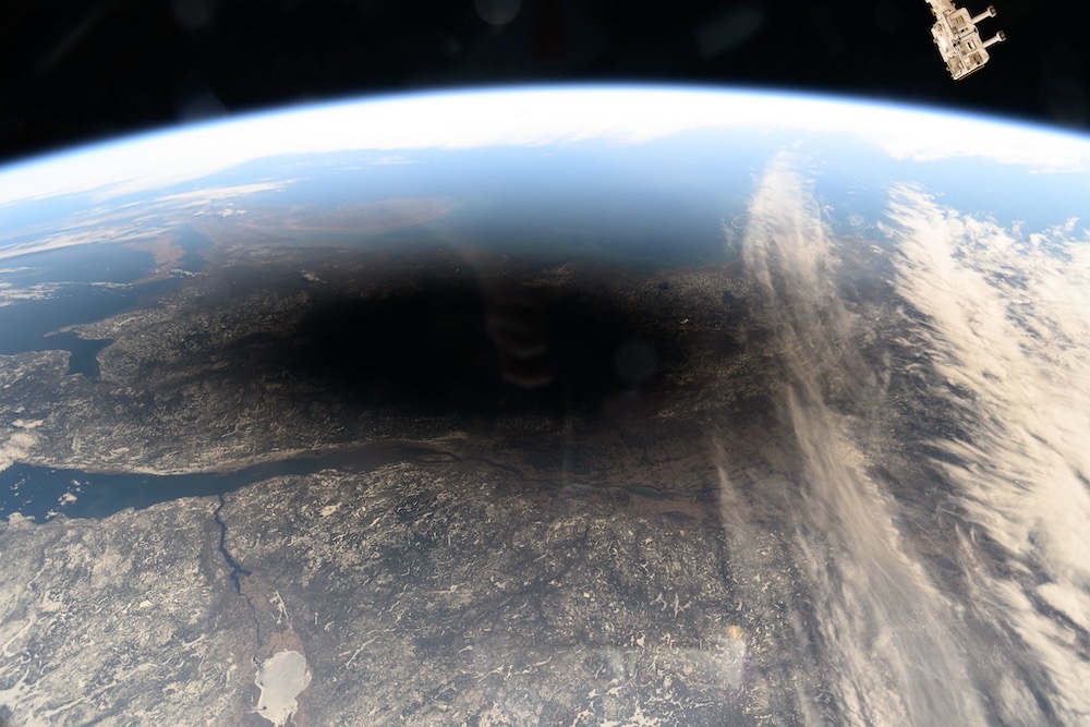 A photo of the earth's surface from the International Space Station, which shows a huge circular black shadow over North America where the solar eclipse happened this week.