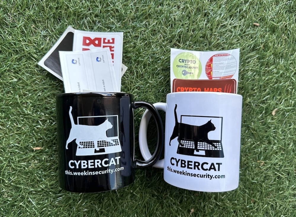 A selection of stickers in a cyber cat themed mug (in both black and white) on a green grassy background.