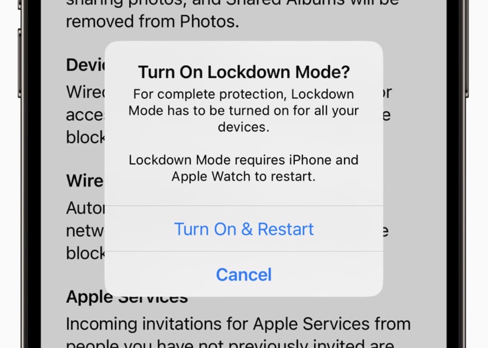 A screenshot of Lockdown Mode being enabled on an iPhone running iOS 17, which says "Lockdown Mode requires iPhone and Apple Watch to restart."