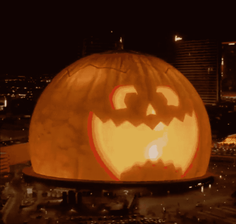 An animated GIF of the Las Vegas "Giant Sphere," which is covered in hundreds of thousands of LEDs, which for Halloween is lit up like an animated jack-o-latern pumpkin that's pulling several faces.