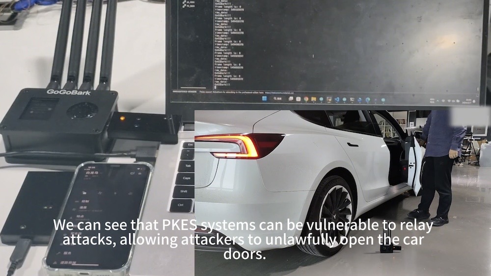 A screenshot of a video on Wired's story, which shows a radio relay device being used to replay a radio attack that unlocks the Tesla's car door. The car's blinkers are on in this screenshot, showing the car unlocking. The caption reads: "We can see that PKES systems can be vulnerable to relay attacks, allowing attackers to unlawfully open the car doors."
