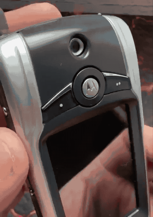 An animated GIF of two mobile phones from the early 2000s, the first has a rotating front-facing camera that hides, and a phone with a rear-facing camera with a privacy cover.