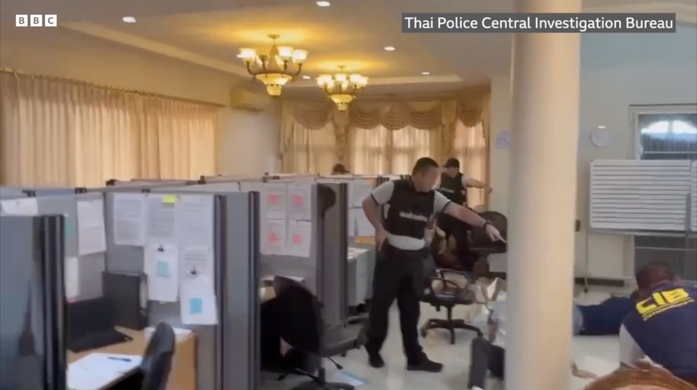 A snapshot from a BBC News video, supplied by Thai police, showing a scam call center in a mansion, with police.