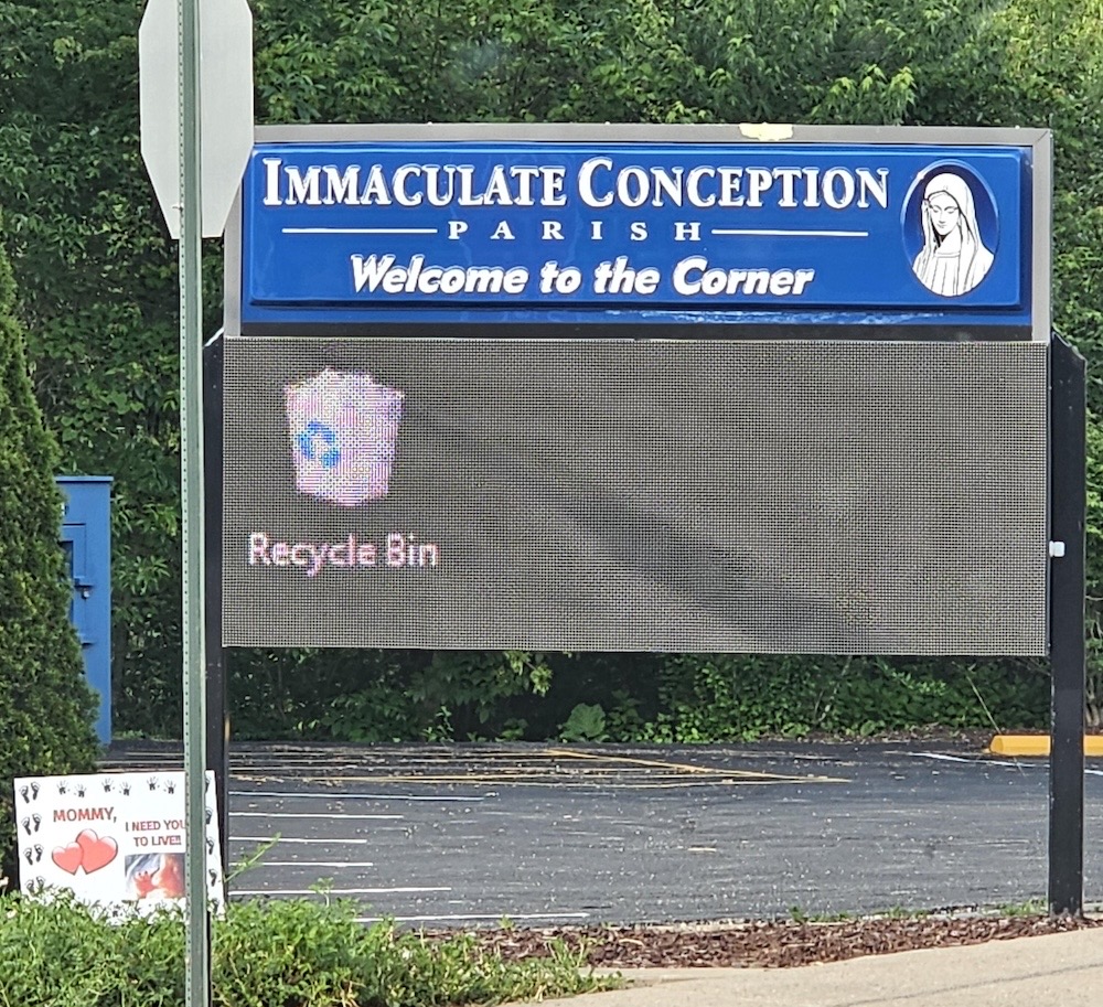 A digital billboard outside a church called the Immaculate Conception Parish, which simply displays a Recycle Bin icon.