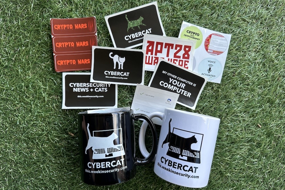 A collection of stickers and mugs (one black and one white) on a green grassy background.