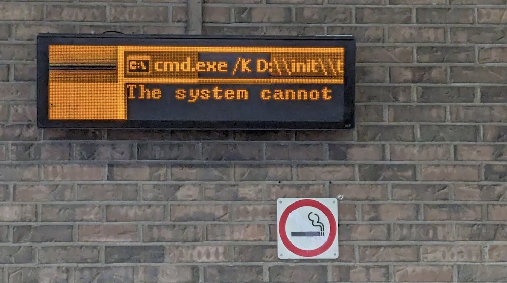 An orange LED digital sign that reads: "cmd.exe" (for a Windows command prompt, followed by the words, "The system cannot"... and the rest of the sentence is cut off. 