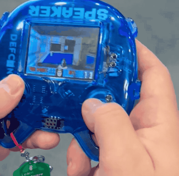 Doom running on a small display featured on the front of a blue Def Con speaker's badge