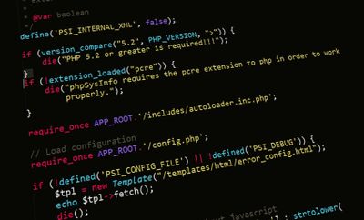 a screenshot showing a bunch of PHP code on a darkened computer display, seen at an angle. 