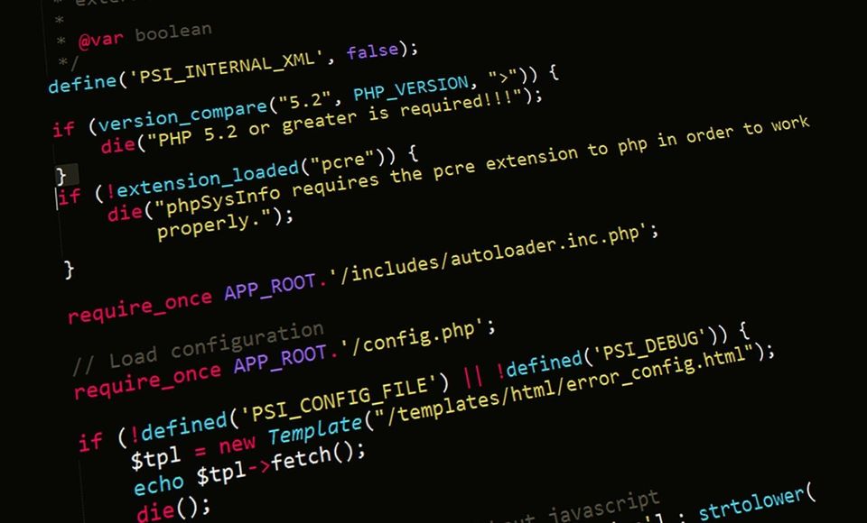 a screenshot showing a bunch of PHP code on a darkened computer display, seen at an angle. 