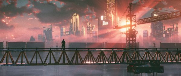 Ya boi looks out over the city from atop a crane, the sunrise breaking from behind the skyscrapers