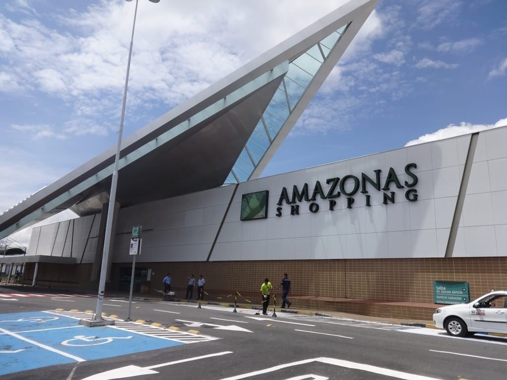 Fachada do Amazonas Shopping em Manaus, com o nome do centro comercial em destaque e uma área de estacionamento à frente
