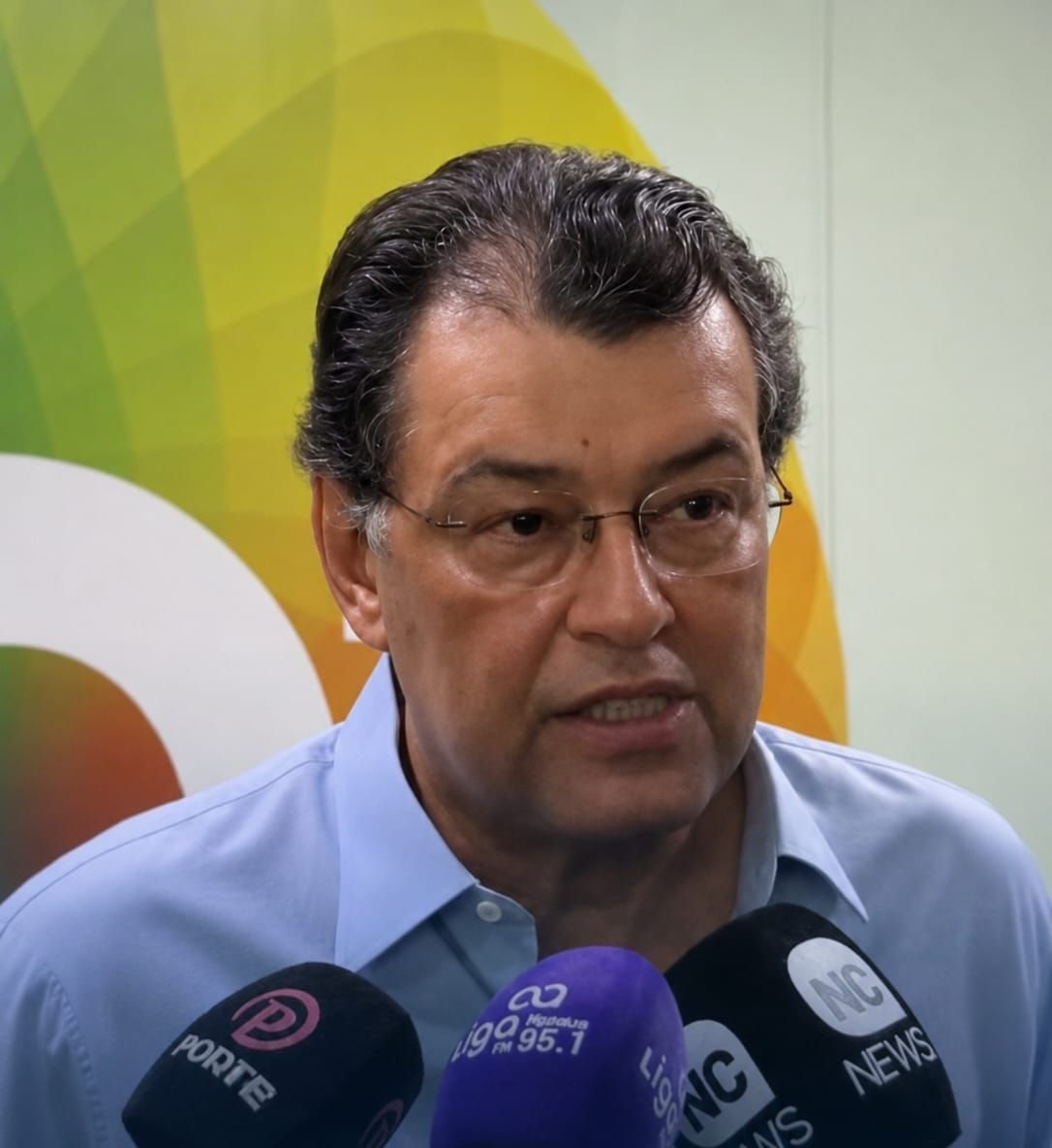 O senador Eduardo Braga concede entrevista cercado por microfones de veículos de imprensa.